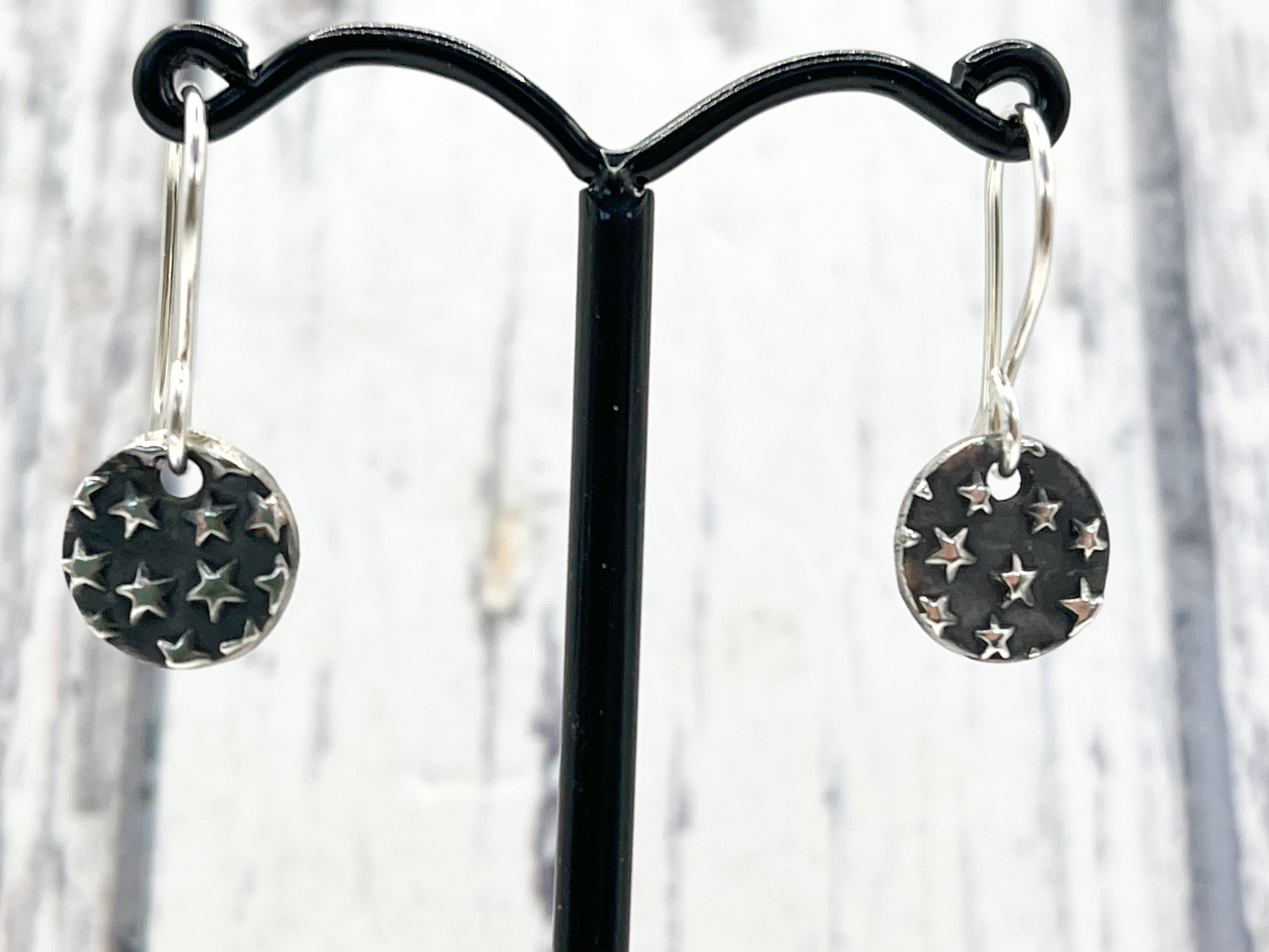 Sterling silver star embossed dangly earrings